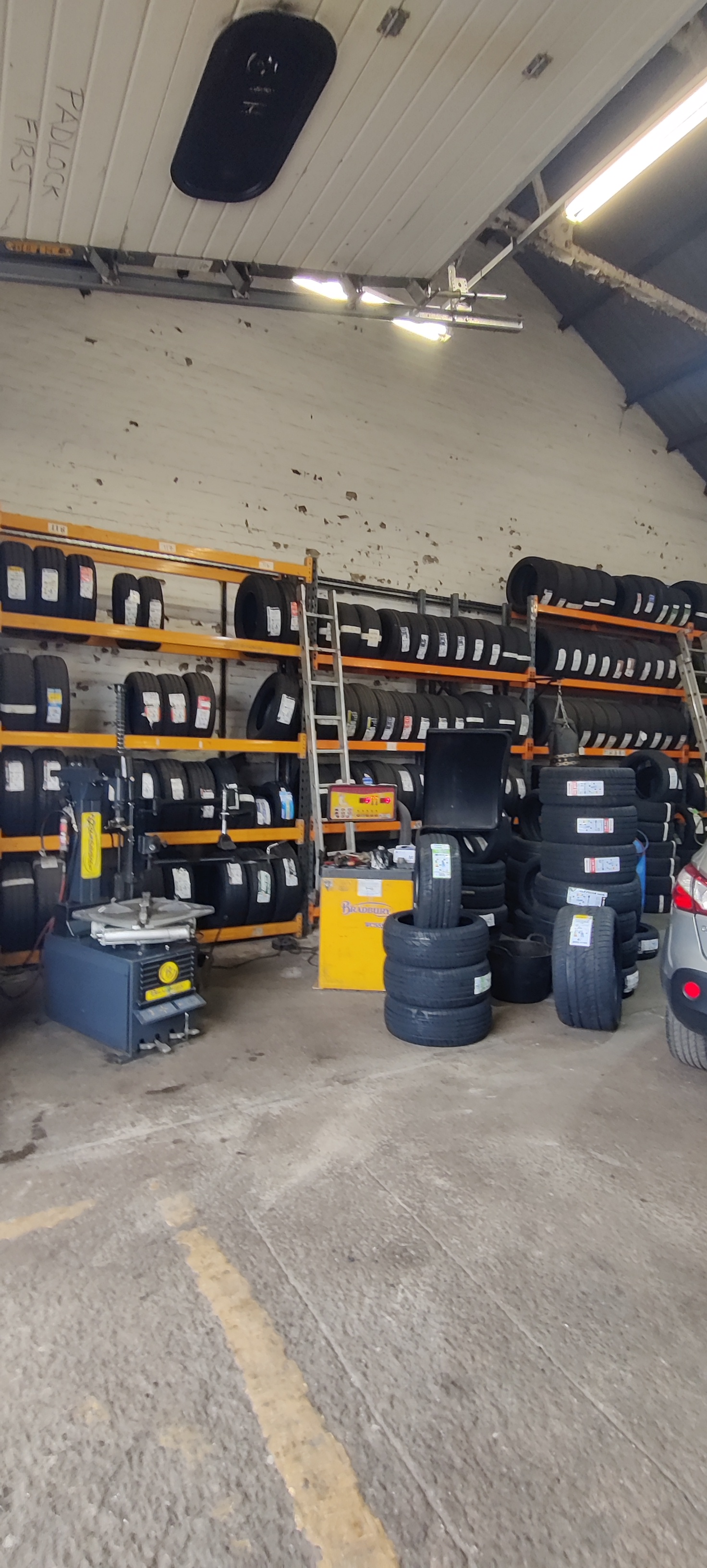 Inside the Cheshire Tyres workshop: racks of tyres, the tyre changer and the wheel balancer