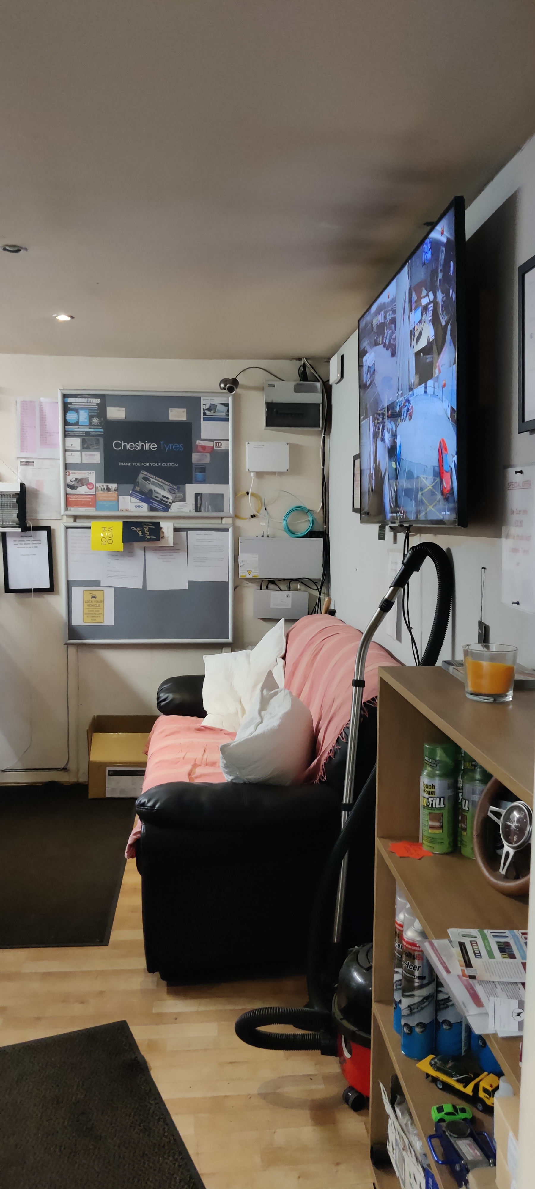 Inside the Cheshire Tyres unit: a sofa, a television and a noticeboard