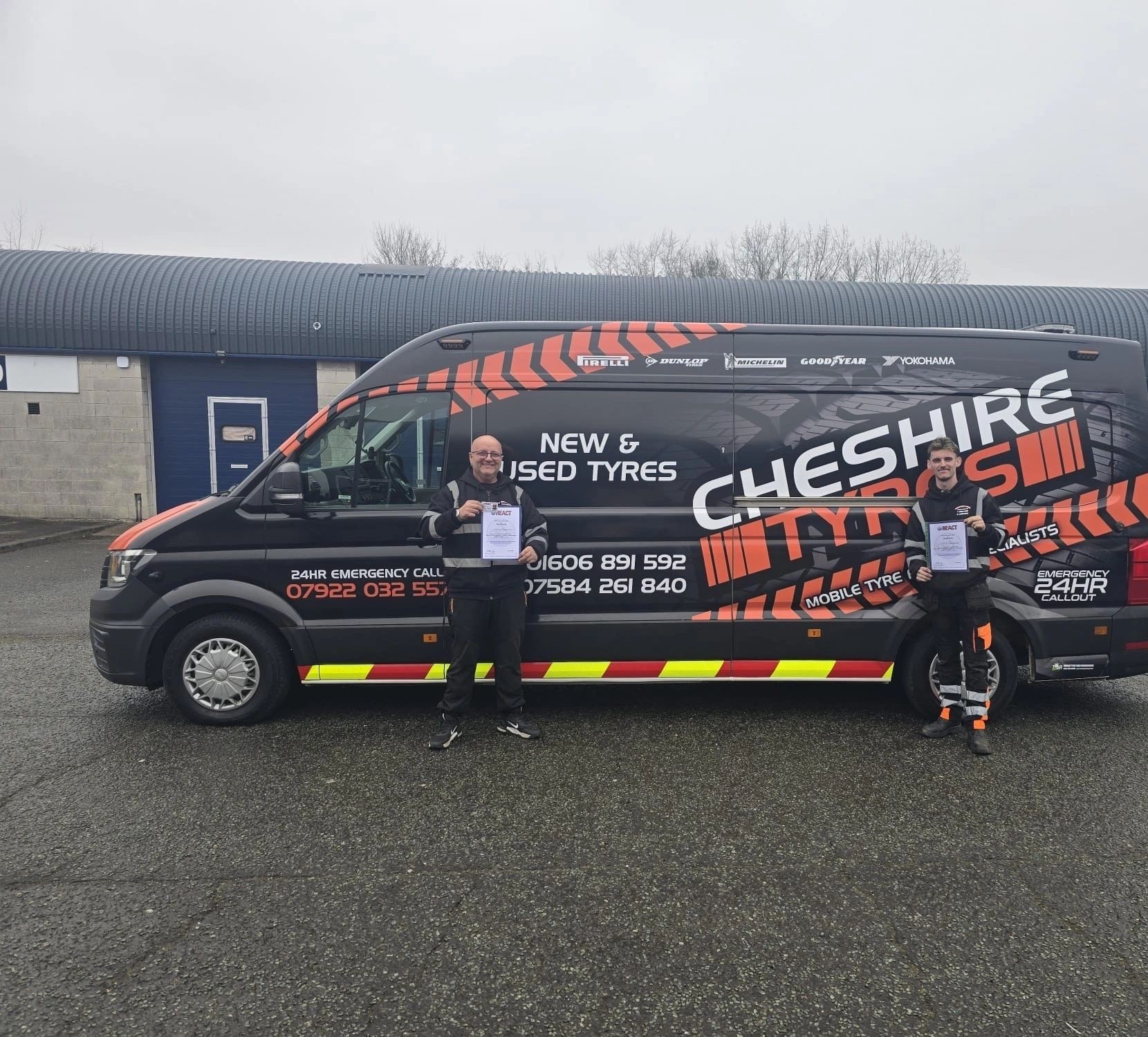 Two of the team holding certificates beside the Cheshire Tyres mobile tyre van